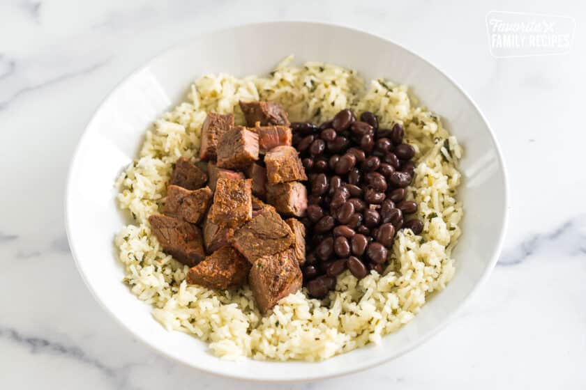 https://www.favfamilyrecipes.com/wp-content/uploads/2024/02/Chipotle-Steak-Bowls-rice-meat-and-beans-840x560.jpg